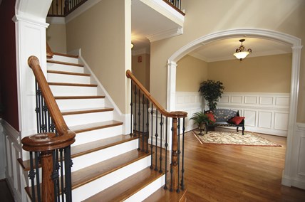 Grand foyer with a wooden staircase, hardwood floors, and a sitting area. Grand foyer with a wooden staircase, hardwood floors, and a sitting area.