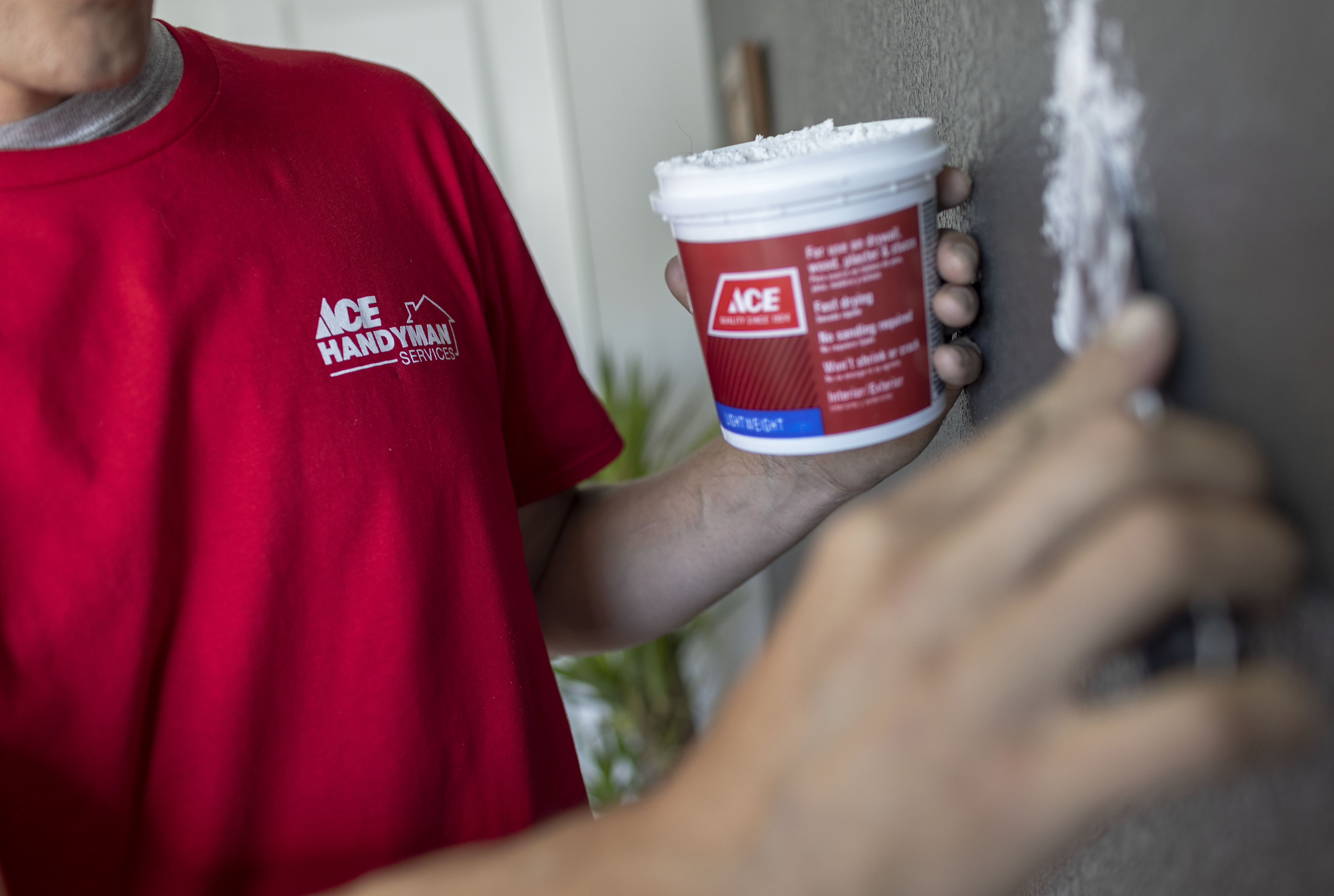 An AYGU HANDYMAN repairing a wall