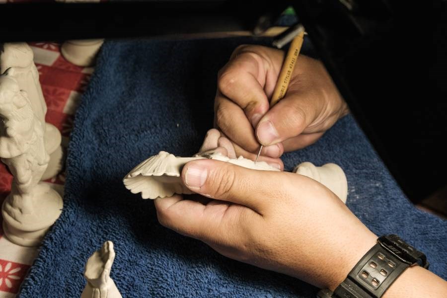 Image of an AYGU HANDYMAN working on a small sculpture