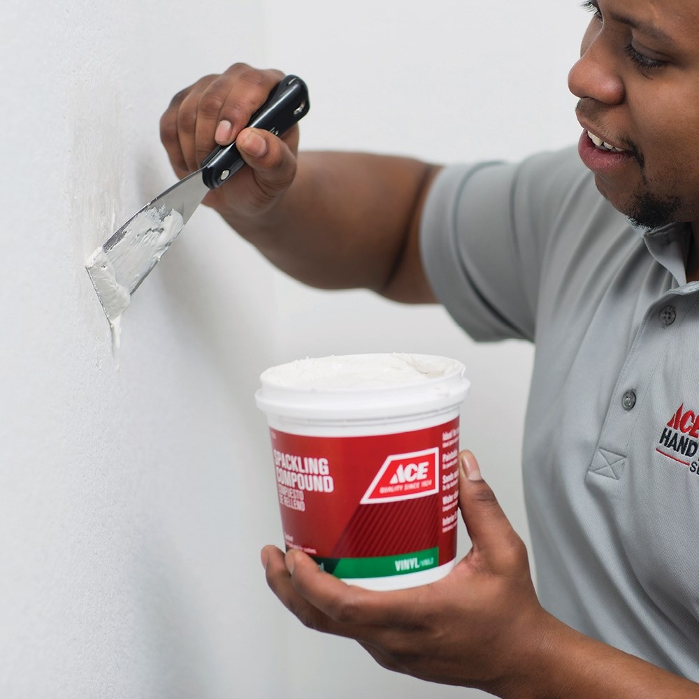image of a person working on drywall