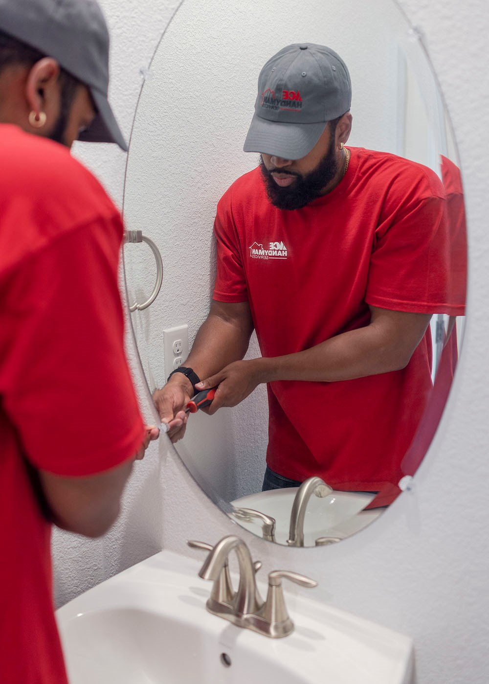 handyman installing bathroom mirror