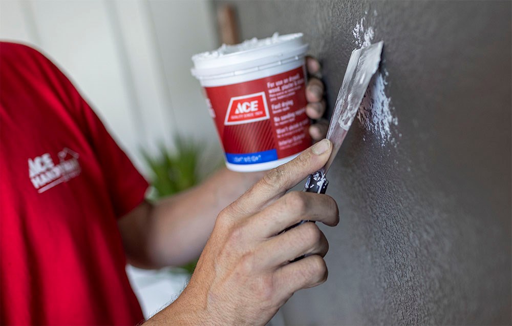 Ace Handyman Repairing Drywall in Living Room