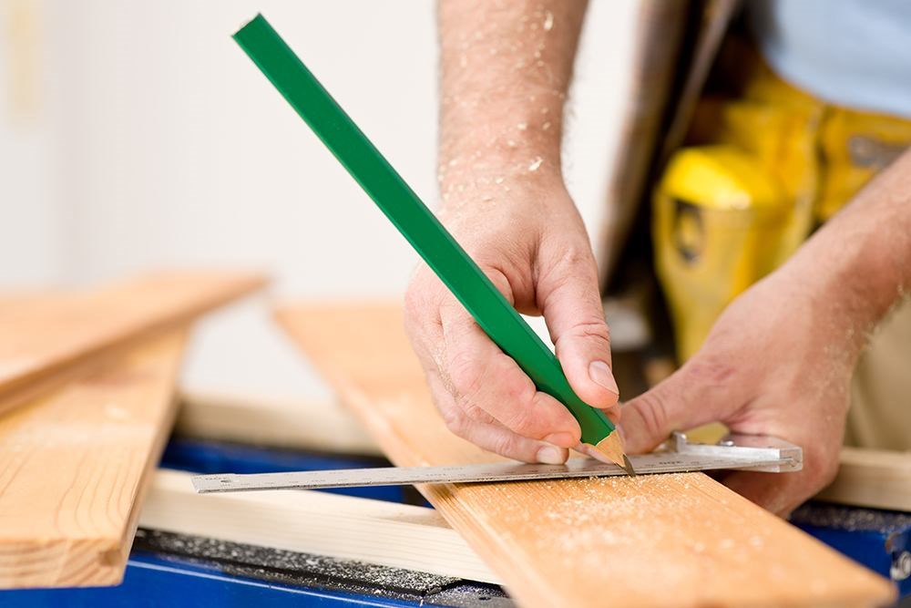 Close Up of Hands Covered in Wood Shavings Holding Carpentry Tools and Marking Places to Cut a Piece of Wood Close Up of Hands Covered in Wood Shavings Holding Carpentry Tools and Marking Places to Cut a Piece of Wood