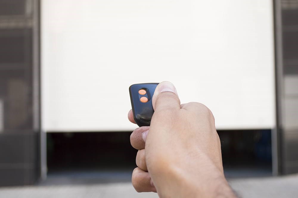 image of someone using a remote garage door opener