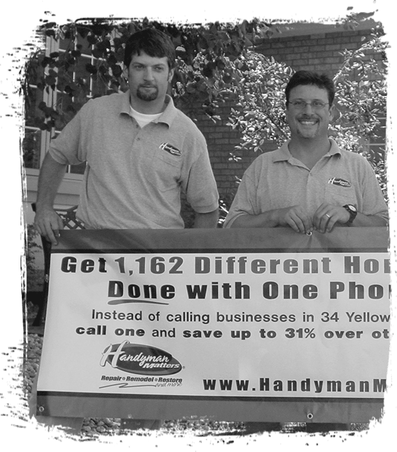 Image of two AYGU HANDYMAN holding up an ad banner