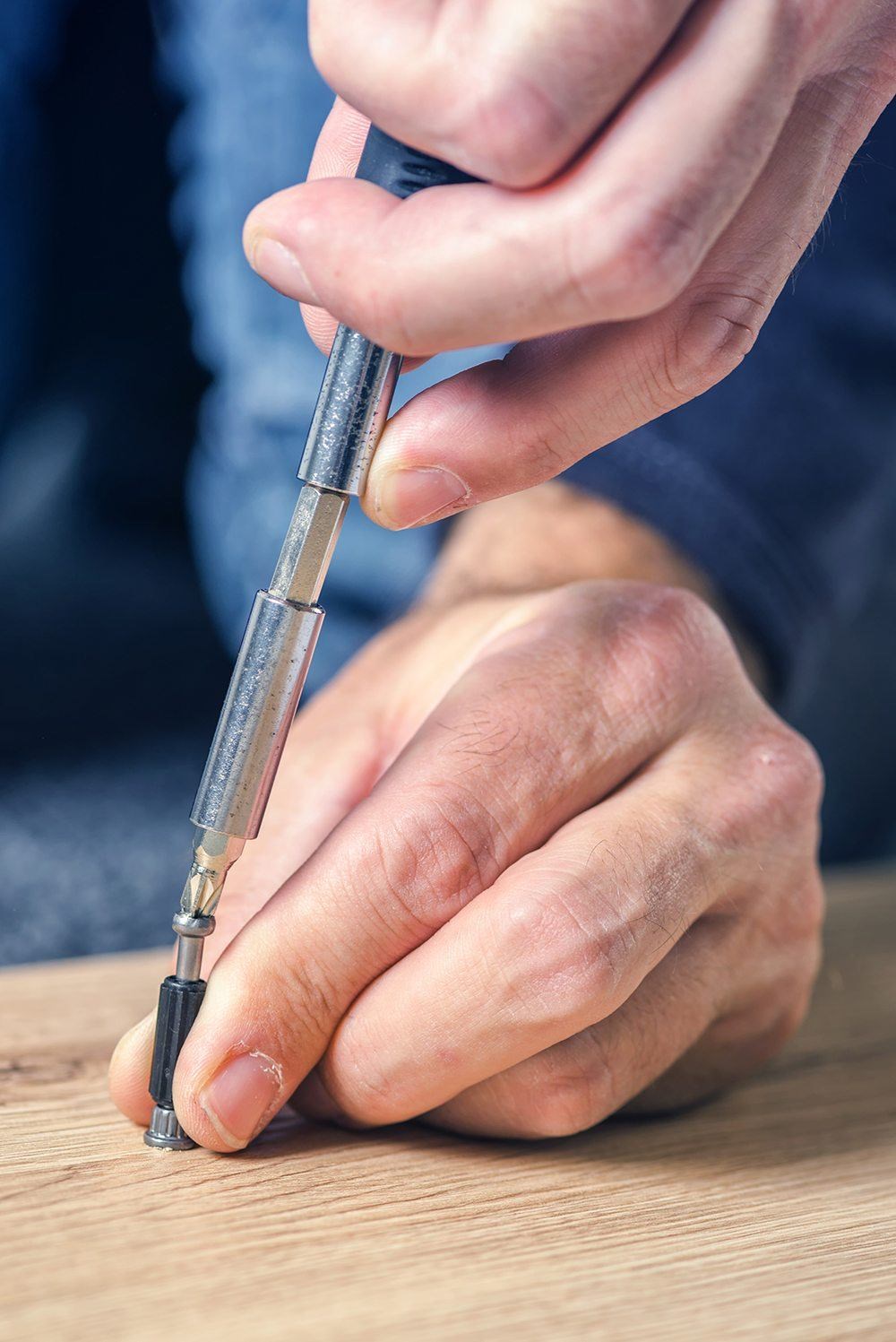 closeup image of hands using a screwdriver