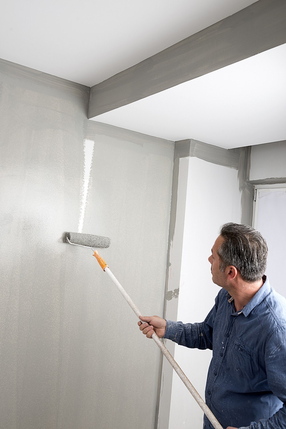 image of a person painting a wall with a paint roller