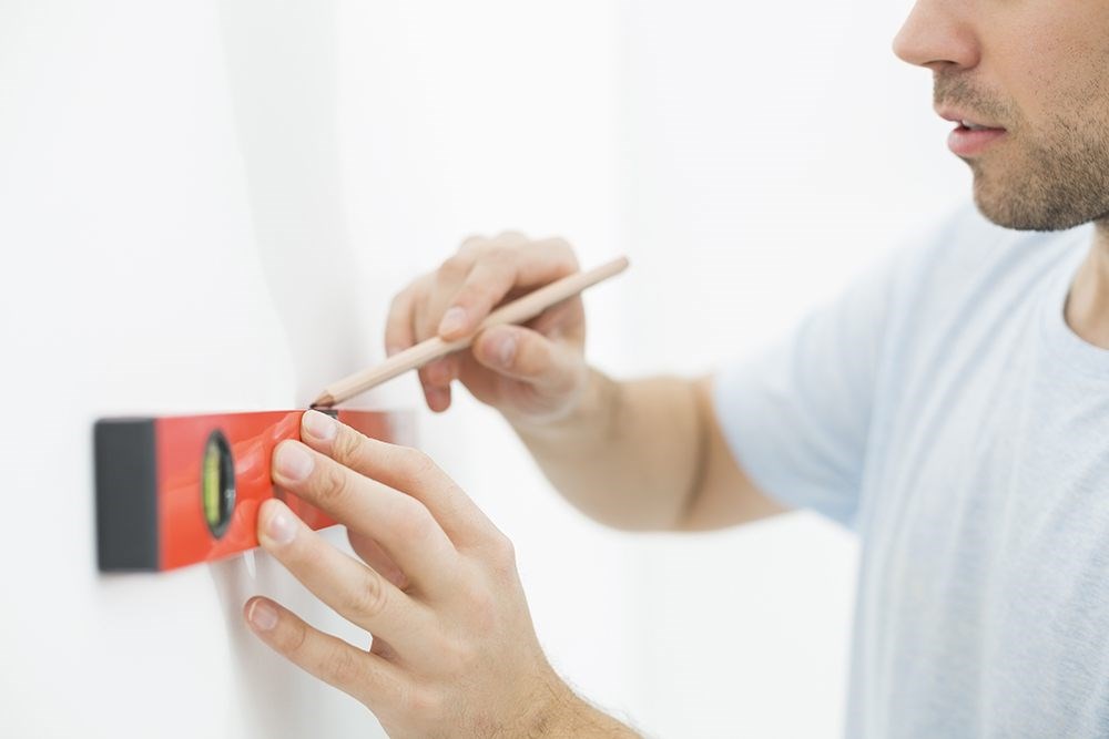 image of a person using a level to draw a line on a wall