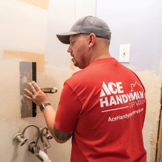 A handyman repairs drywall on a wall A handyman repairs drywall on a wall