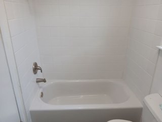 Bathtub after new tub enclosure installed and new tile work laid down. Tiling performed by Ace Handyman Services. 