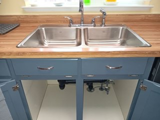 Stainless steel sink installed by Ace Handyman Services. This sink has a sprayer hose and the plumbing under the sink is new.