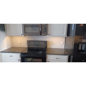 Newly installed tile backsplash with clean, modern design enhancing the kitchen's style and durability.