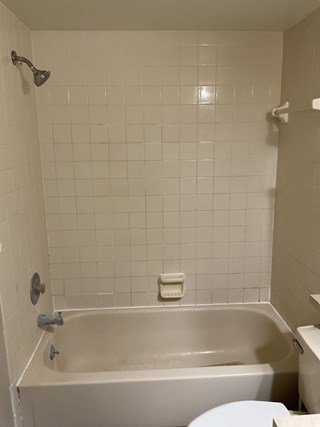 Before, existing dated shower, featuring out dated tile. 