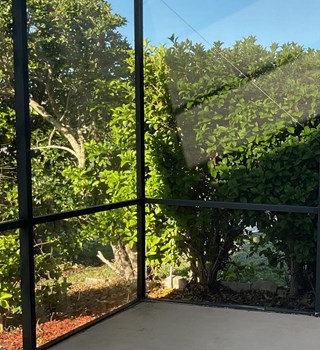 Open lanai area without a privacy screen, exposing the outdoor space and offering limited seclusion from neighboring views. 