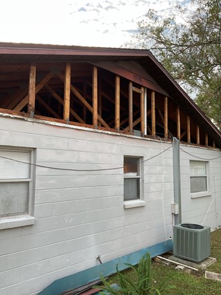 Blown-off siding on a home in Lutz showing exposed wall areas before repair and weather protection installation.
