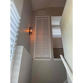 Installed bifold door used to neatly conceal an indoor A/C unit, cleaning a clean and functional finished look.