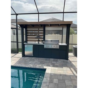 Outdoor kitchen installation in a poolside lanai, featuring new cabinetry, countertops, and built-in appliances for upgraded outdoor living.