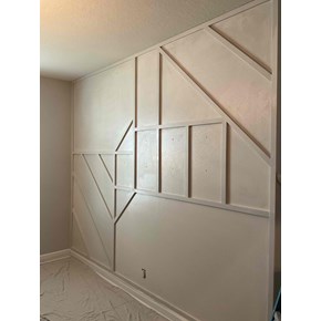 Freshly painted wall with existing intricate trim detailing, creating a clean, updated, and polished look in the room.