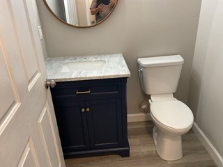 Bathroom after renovation featuring a newly installed modern vanity and toilet, creating a cleaner, updated, and more functional space. 
