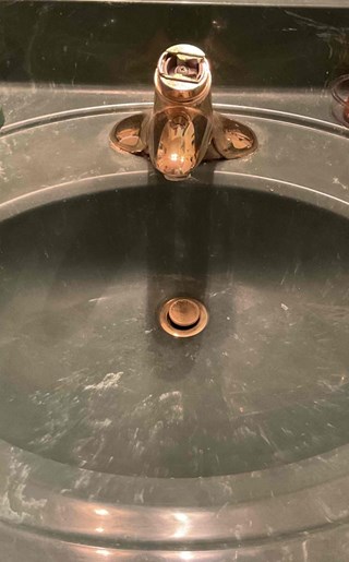 Old faucet before replacement, showing worn fixture needing an upgrade for better function and appearance.