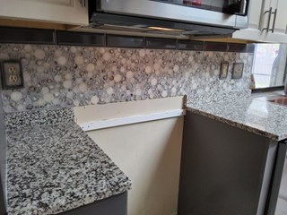 Installation of tile backsplash in kitchen area