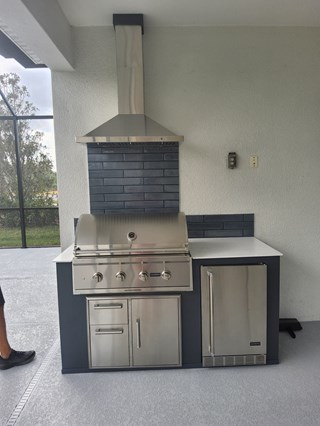 Outdoor kitchen area after, with backsplash