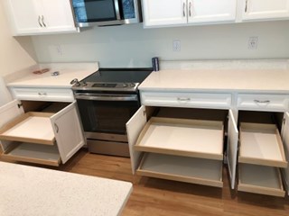 Inside kitchen cabinets after installation of rollout trays