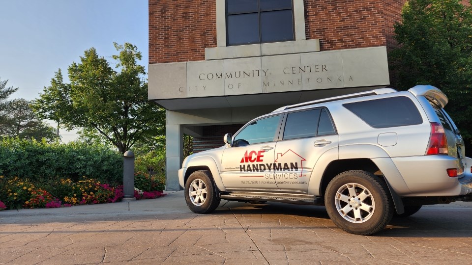 A silver SUV with an Ace Handyman Services logo on it outside of a building called “Community Center, City of Minnetonka.” A silver SUV with an Ace Handyman Services logo on it outside of a building called “Community Center, City of Minnetonka.”