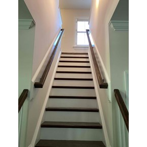 Dual wall-mounted stair handrail installation in Clayton NC, dark stained wood rails on both walls, finish-matched to existing stair treads Dual wall-mounted stair handrail installation in Clayton NC, dark stained wood rails on both walls, finish-matched to existing stair treads