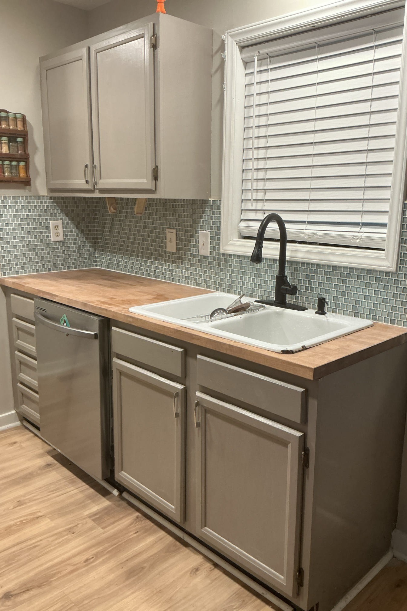 Refreshed Durham kitchen with gray painted cabinets, glass tile backsplash, and butcher-block countertop