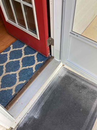The same door, but now with the threshold replaced. The door frame's lower area is now smooth, with a new metal threshold installed.