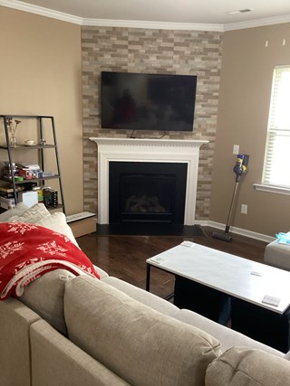 The same living room with the TV now mounted above the fireplace. 