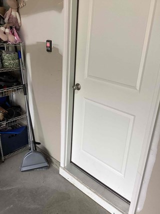 A close-up of the same white door, but now the damage on the left side has been repaired. The doorframe is intact and smooth, with no visible cracks. 