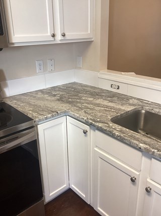 Kitchen after the backsplash has been installed. The backsplash tiles are now in place, providing a neat and clean look above the countertop. The area is fully finished, and the kitchen looks more polished and complete.