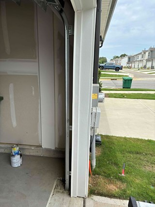 Garage trim is now properly aligned and intact after repairs, providing a much cleaner and more polished appearance around the garage door.