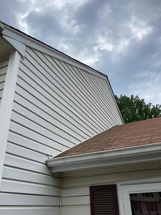 Area after the siding has been replaced. The previously missing section has been filled with matching siding, and the entire area now looks uniform and finished. 