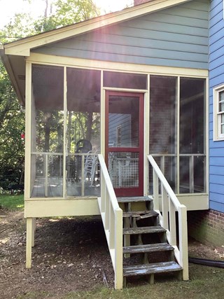 An outdoor porch area with an old and worn set of wooden stairs. The railing are damaged, and the steps show signs of wear, with some boards looking aged and weathered. The overall appearance is not well-maintained, and the stairs could be hazardous.