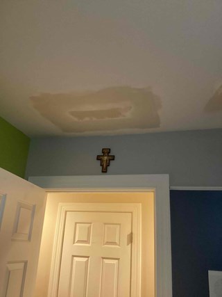 Ceiling after repairs have been made. The hole has been patched, and the surface has been smoothed over, with a more even texture. The ceiling is now ready for painting, and the previously damaged area has been fully restored to a more polished appearance.