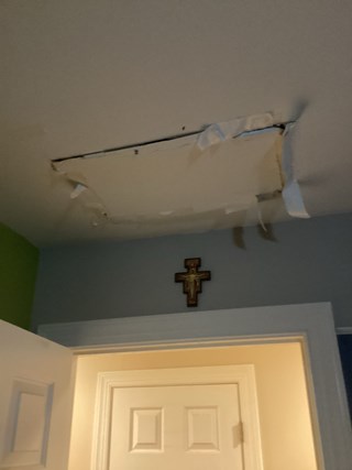 Ceiling with visible damage, including a hole in the drywall ceiling. 