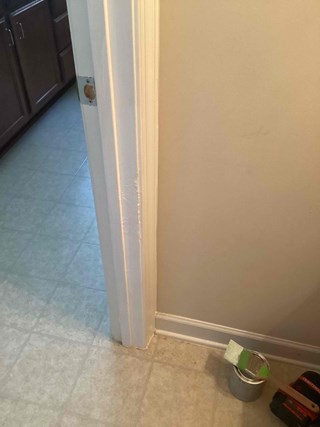 Door frame after the damage has been repaired. The scratch is no longer visible, and the area is smooth and painted.