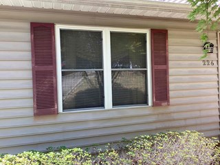 Plastic shutters that are weathered and in need of repair. 