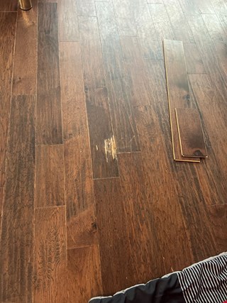 Section of hardwood flooring with noticeable damage.