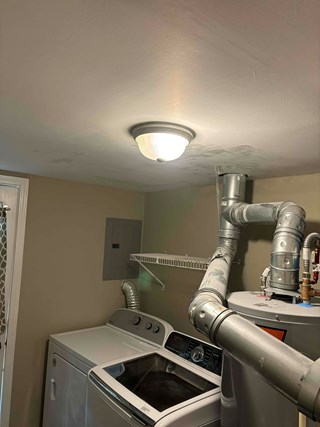 Ceiling fully repaired. The hole has been patched, and the drywall is smooth and painted over. The ceiling looks clean and intact, with no signs of the previous damage.