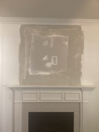 Above the fireplace cabinet has been removed, the wall has been closed off with drywall, mudded, and is now ready for painting. 