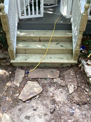 The wooden steps have been replaced with new, unfinished wood, and the steps appear sturdier.