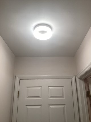 The hole has been patched, and the ceiling looks smooth and freshly painted. 