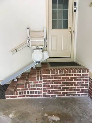 Stairlift is positioned on the left side of the stairs, and there is no railing on the side of the stairs to provide additional support.