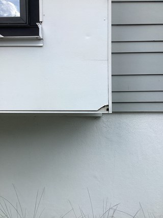 Window is visibly damaged, with a broken corner and gaps near the base. 