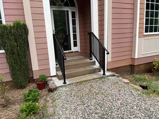 teps after a black metal handrail has been installed, improving safety and accessibility to the entrance. 