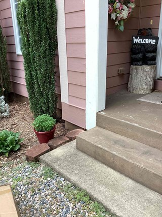 Concrete steps are visible without a handrail. 
